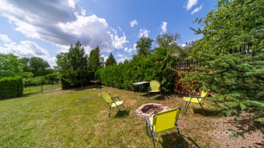 Příjemná venkovská zahrada s rekreačním karavanem a terasou.