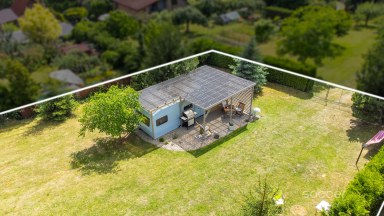 Příjemná venkovská zahrada s rekreačním karavanem a terasou.